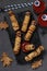 Spooky sausage mummies, tomato juice and sauce for Halloween party on dark wooden board. View from above. Flat lay. Vertical