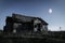 Spooky scene of haunted house and moon.Old mystic building at dead tree.Horror Halloween concept.Toned