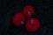 Spooky season. Three orange red round pumpkins in a dark green grass outdoors atmospheric photo.