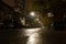 Spooky street in the fog. Wet road, autumn trees and night lights. Halloween night.