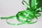 Spool of green curling ribbon on a white background