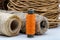 Spool of orange thread on a background of rough twine