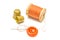 Spool of orange thread, and two thimbles
