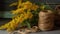 a spool of twine next to a spool of twine and a spool of yellow flowers on a wooden table with a string