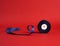 Spool of twisted dark blue silk shiny ribbon on a red background