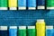 Spools of blue, yellow and green sewing thread arranged in two rows on denim with copy space