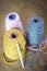 Spools of Pink, Yellow, and Gray Yarn and a Crochet Needle