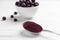 Spoon with acai powder and fresh berries