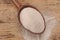 Spoon with active dry yeast on wooden table, above view