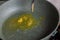 spoon adding butter to vegetable oil on empty preheated skillet