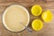 Spoon in bowl with dough for muffins, silicone molds on table. Top view