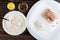 Spoon in bowl with flour, salt, condiment in bowl, pressed piece of pollock fillet, flour in dish on wooden table. Top view