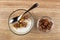 Spoon in bowl with granola, yogurt, chocolate, bowl with porous chocolate on table. Top view