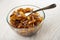 Spoon in bowl with preserve from slices of apple and cinnamon on wooden table