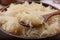 Spoon and bowl of tasty sauerkraut, closeup view