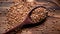 Spoon with buckwheat on the background of dark burnt wood. Rustic style