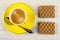 Spoon, coffee in cup on saucer, wafers with filling on wooden table. Top view