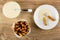 Spoon, condensed milk in bowl, breadsticks with poppy in bowl, breadsticks with condensed milk in saucer on table. Top view