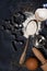 Spoon with flour, forms and ingredients for baking on a black background, vertical closeup