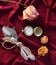 Spoon, fork, dry roses, pocket watch on a red silk tablecloth. Romantic dinner. Top view