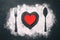 Spoon, fork and plate with red heart, flour sprinkled around the