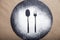 Spoon and fork silhouette made with flour on the dark texture background