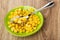 Spoon on green saucer with canned sweet corn on table