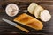 Spoon in jar with krill paste, knife, loaf of bread, bread, sandwich with krill paste on wooden table. Top view