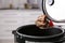 Spoon with meat and vegetables over modern multi cooker in kitchen, closeup