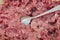 Spoon in minced pork. Close-up. Ground meat for dumplings.