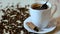 Spoon mix black coffee in white cup and cinnamon on saucer and roasted coffee beans