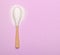 A spoon with natural sweetener lies on a pink background