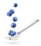 Spoon with natural yogurt and falling blueberries isolated on white background