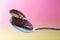 Spoon with pecan kernel and jam on smooth pink background