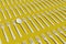 A spoon among a pile of forks on a yellow background. 3d illustration