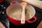 A spoon resting on top of a pot with soup boiling in it