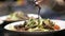 Spoon with sauce is poured over salad. Action. Closeup of aesthetic pouring jets of salad sauce by professional chef in
