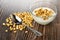 Spoon on scattered puffed wheat, bowl with yogurt and puffed wheat on wooden table