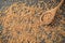 Spoon and scattered wheat grains on grey background