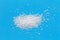 Spoon of sugar scattered on a bright blue background