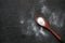 spoon of white sweetener on a black background .