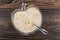 Spoon in yogurt with oat bran in bowl on table