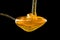 Spoonful of honey on the black background