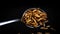 Spoonful of mealworms, edible snack insects isolated on black background. Mealworm larvae as food. Fried roasted worms. Animal