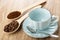 Spoons with coffee beans, ground coffee, empty cup, spoon on saucer on table