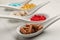 Spoons with different dietary supplements on white table, closeup