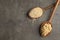 Spoons with raw and cooked quinoa on table, top view.