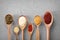 Spoons with tasty sauces on grey background