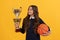 sport achievement award. teen girl with basketball ball and champion cup.