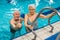 Sport and active leisure time for pensioners. Two positive caucasian senior adults near a pool ladder. Senior man